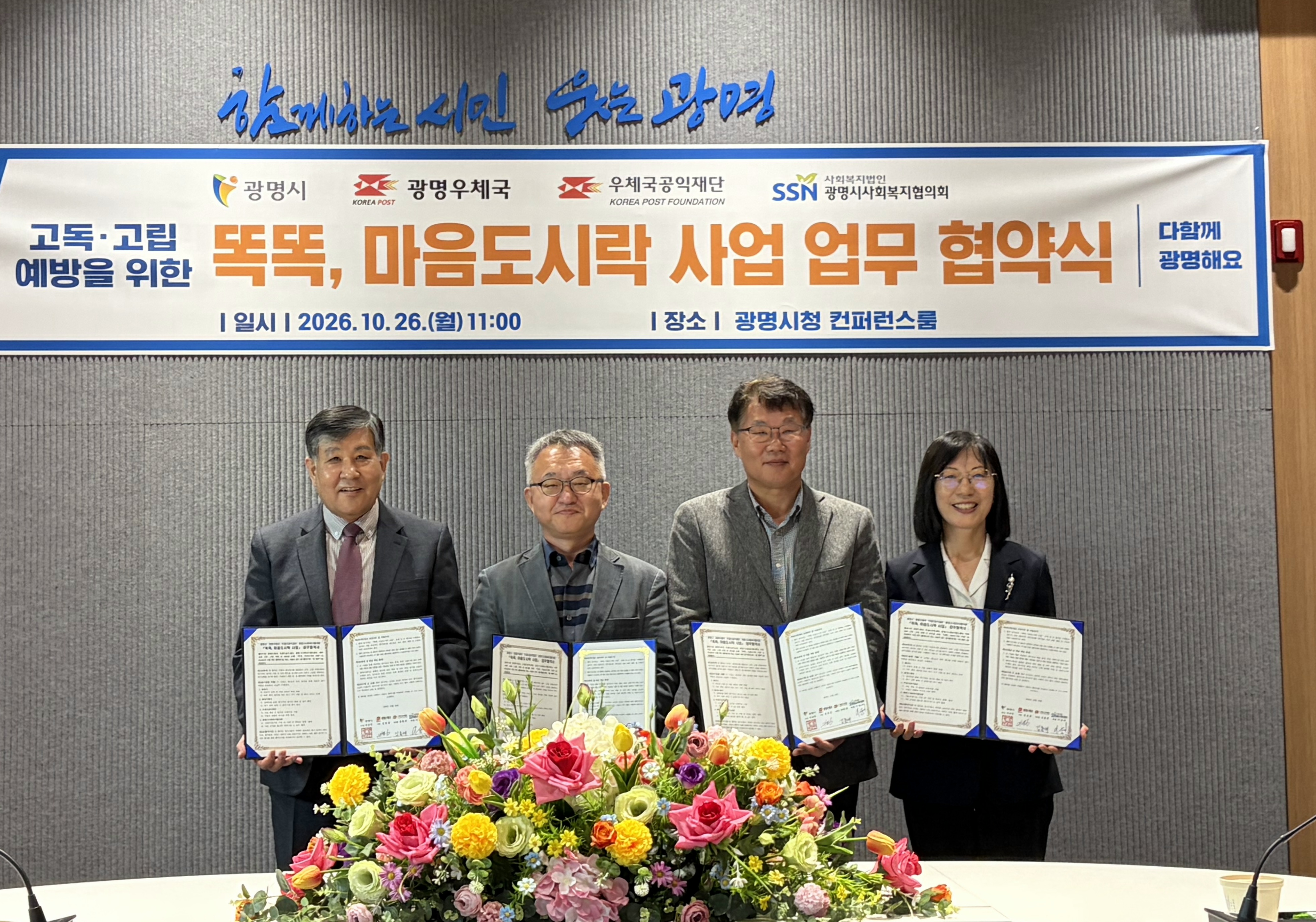 황희민 광명시 돌봄복지국장(사진 왼쪽에서 네 번째)이 2026년 10월 26일 오전 10시 시청 컨퍼런스룸에서 이상재 광명시사회복지협의회장(왼쪽에서 첫 번째), 김유승 광명우체국장(왼쪽에서 두 번째), 김홍재 우체국공익재단 이사장(왼쪽에서 세 번째)과 ‘똑똑, 마음도시락 사업’ 업무협약을 체결하고 기념사진을 촬영하고 있다.