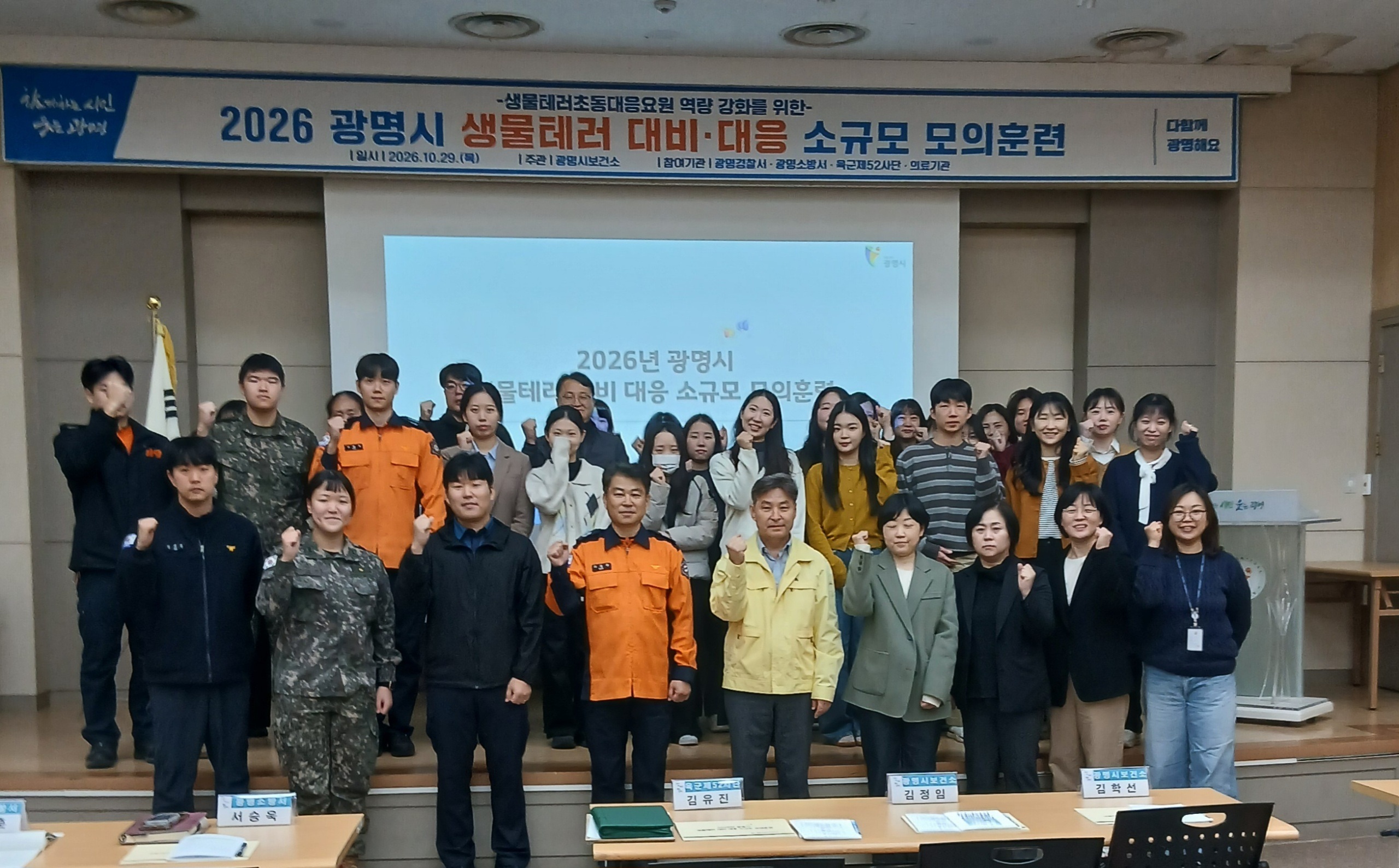 (광명4) 29일 광명시보건소 대회의실에서 열린 '2026년 생물테러 대비·대응 소규모 모의훈련'에 참여한 보건소, 경찰, 소방, 군 등 초동대응기관 관계자들이 기념사진을 촬영하고 있다.