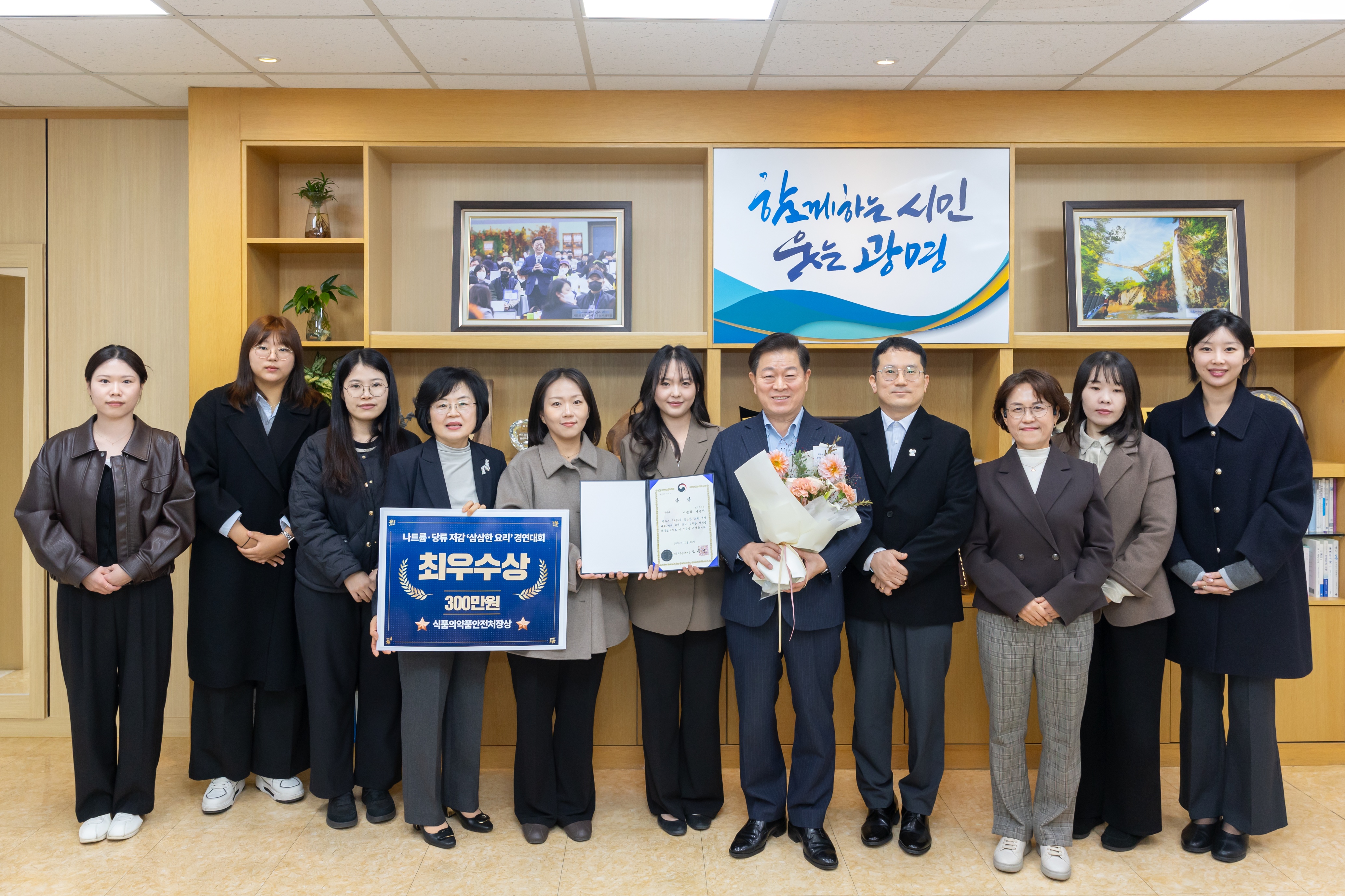 (광명2)박승원 광명시장이 ‘삼삼한 요리 경연대회’에서 최우수상(식품의약품안전처장상)을 받은 것을 기념해 보건위생과 직원들과 기념사진을 촬영하고 있다.