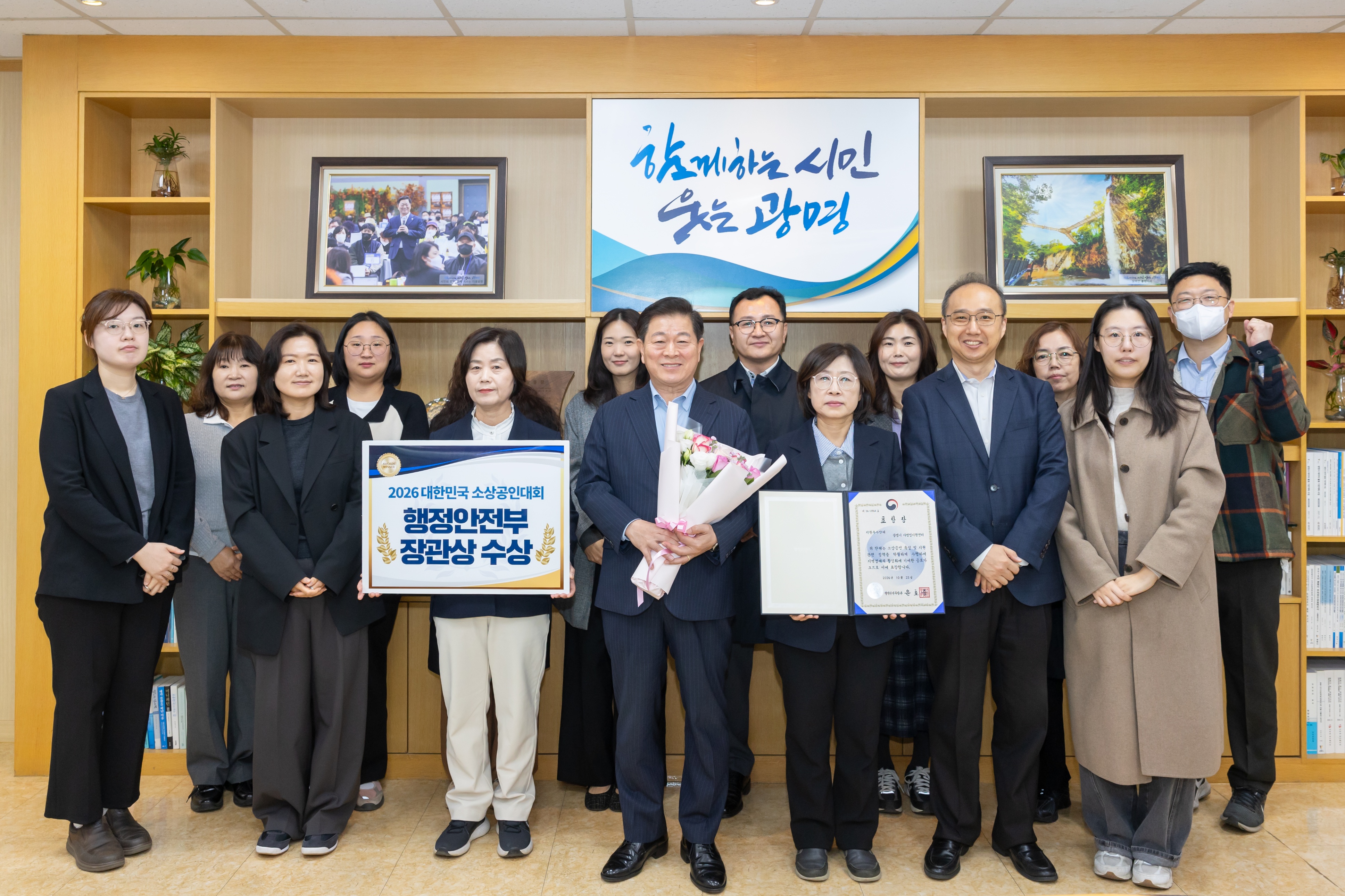 (광명1)박승원 광명시장이 ‘2026 대한민국 소상공인대회’에서 행정안전부 장관상을 받은 것을 기념해 일자리경제과, 자영업지원센터 직원들과 사진을 촬영하고 있다.